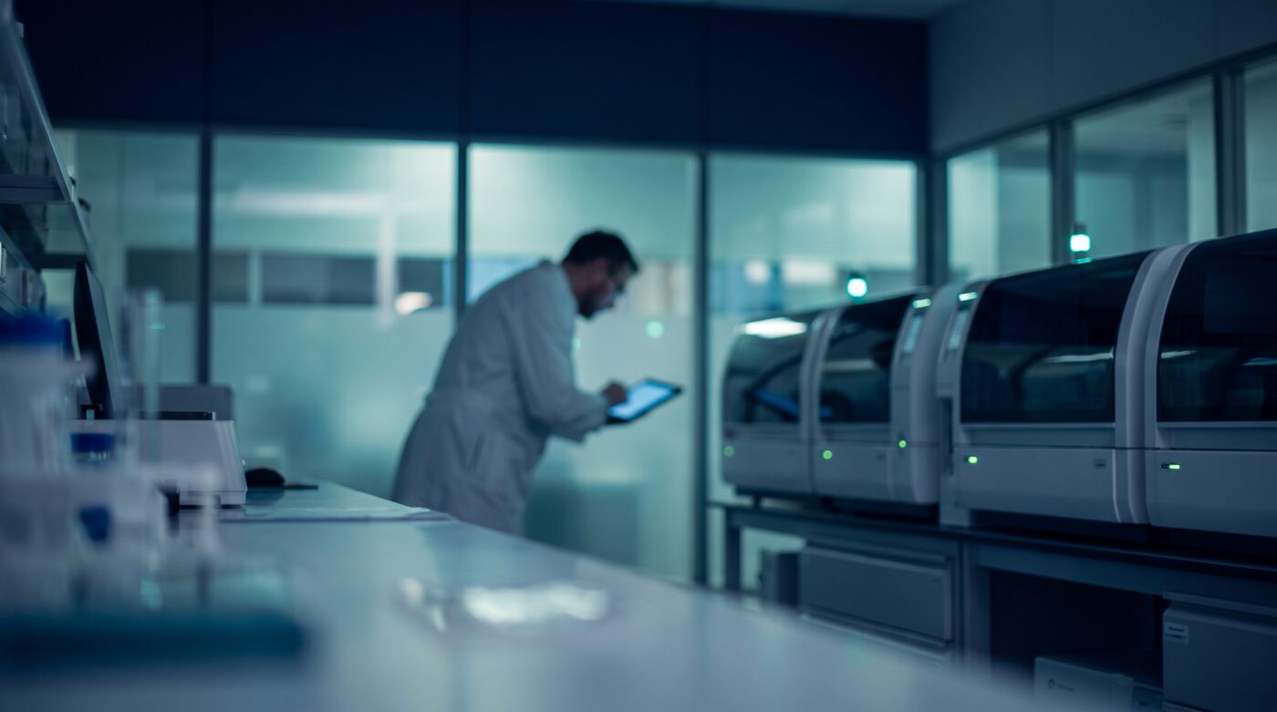 Soft-focus modern molecular diagnostics laboratory interior with automated analyzers, navy and teal editorial photograph representing clinical laboratory regulation and CLIA compliance